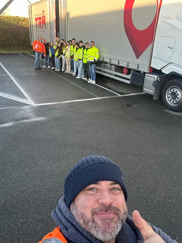 Groupe d’étudiants en gilets haute visibilité devant un camion du groupe Coué TRM lors d’une visite transport routier