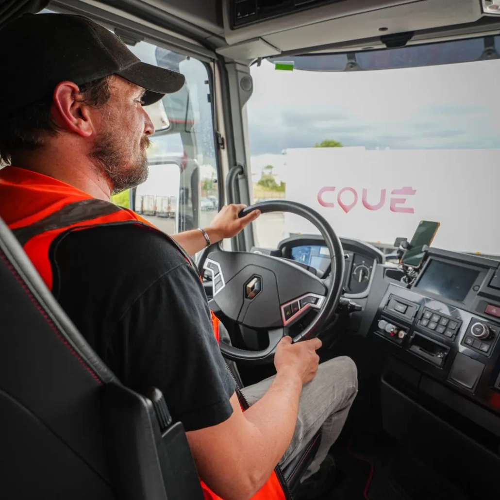 Conducteur routier du Groupe Coué TRM en cabine de camion, solution de transport routier et location avec chauffeur expérimenté