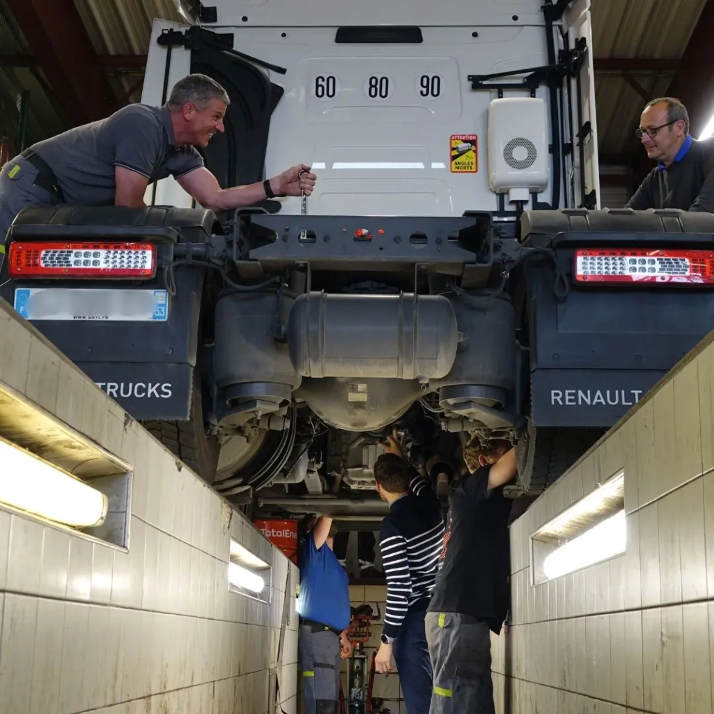 groupe-coue-trm-atelier-mecaniciens Équipe de mécaniciens poids lourds Groupe Coué TRM intervenant sur un camion Renault Trucks en atelier de maintenance spécialisée